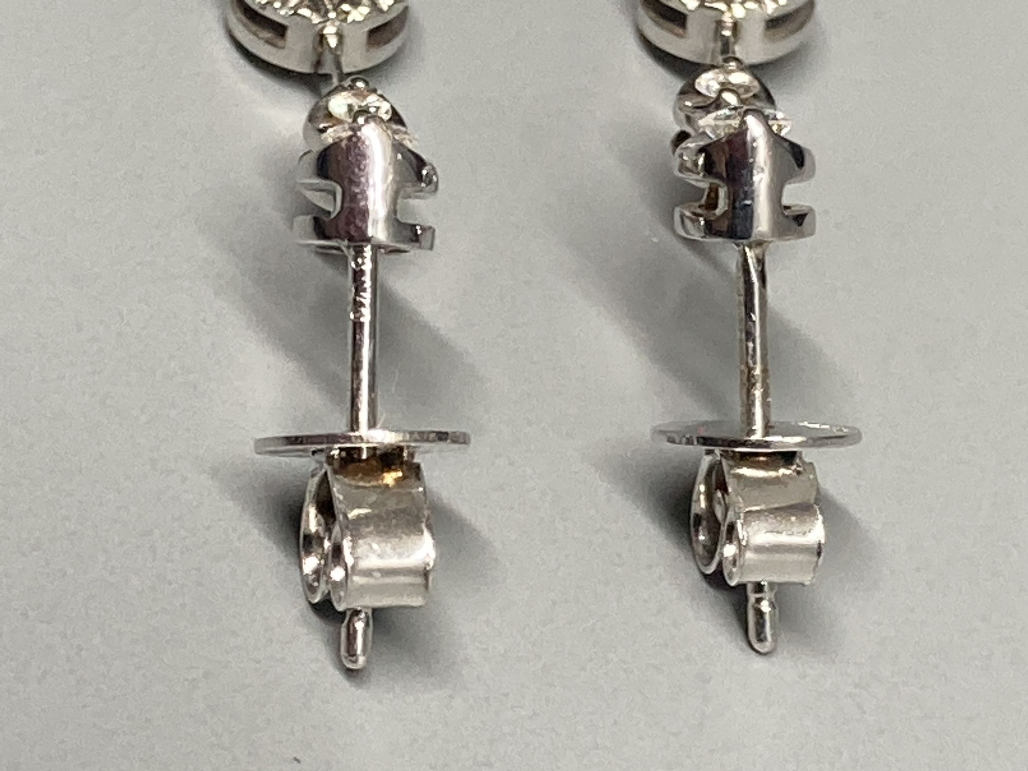 A modern pair of 18ct white gold and illusion set three stone diamond drop earrings, 19mm, gross 2.3 grams.